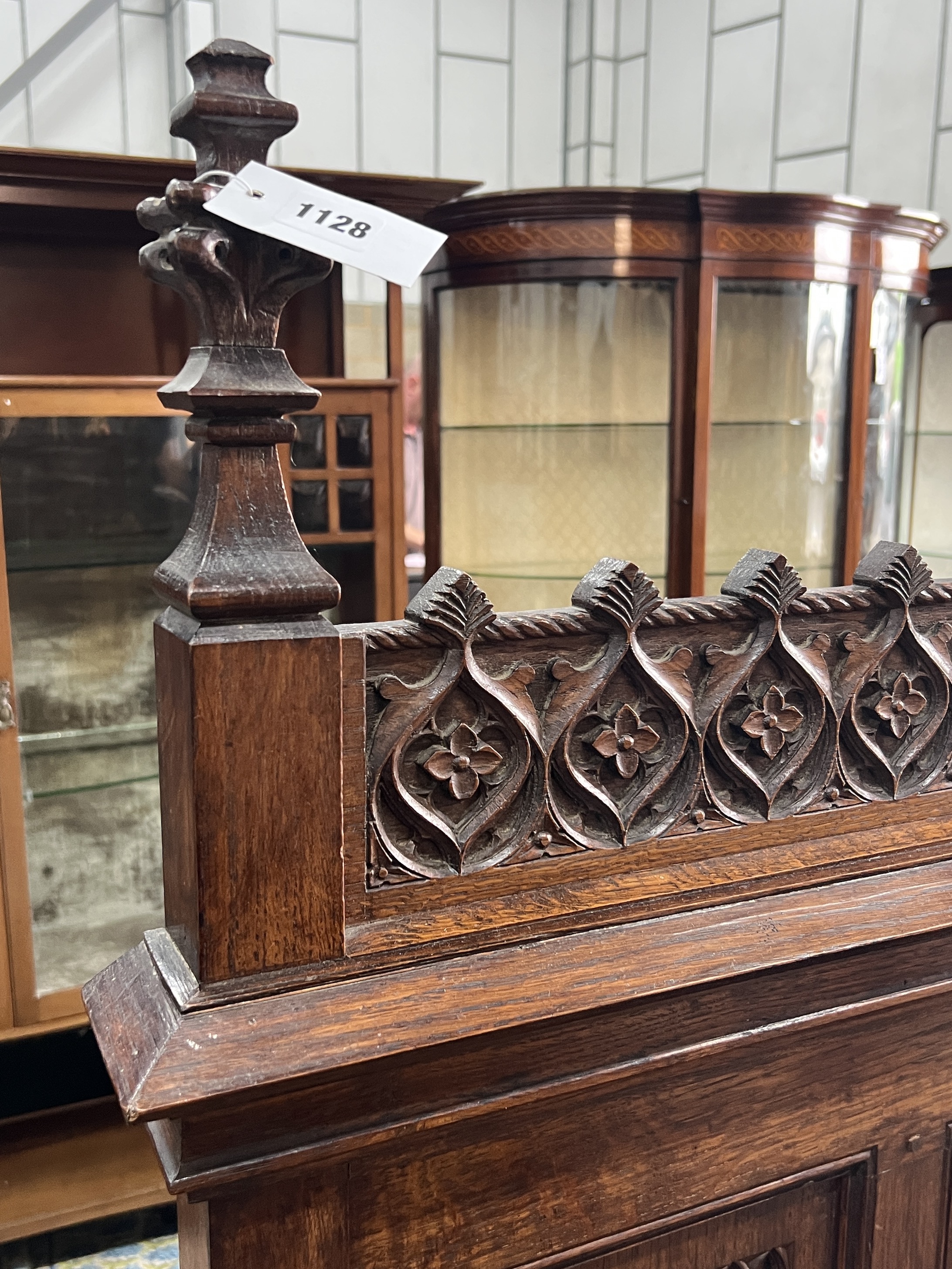 An early 20th century carved oak Gothic Revival settle with hinged box seat, width 137cm, depth 49cm, height 160cm